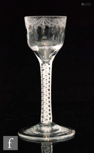 An 18th Century drinking glass with a fluted ogee bowl with engraved upper swag border above a