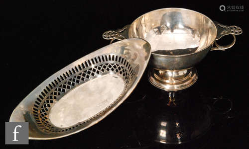 A hallmarked silver small pedestal bowl of plain form with pierced details to twin handles, with