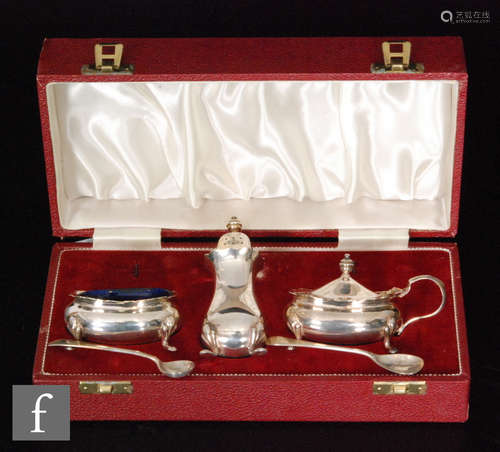 A cased hallmarked silver three piece cruet of plain boat shaped form, each raised on four pad feet,