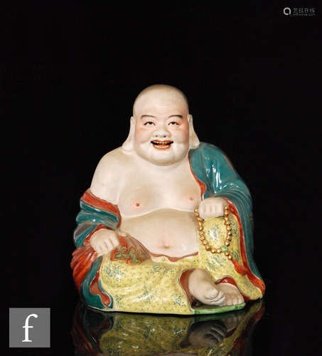 A 20th Century Chinese study of a seated Buddha wearing in tonal red, yellow and turquoise