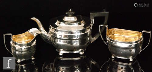 A hallmarked silver three piece boat shaped tea set of plain form each raised on four bun feet,