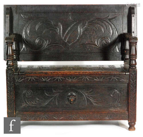 A late 19th to early 20th Century carved oak monks bench with detailed florette design, the top