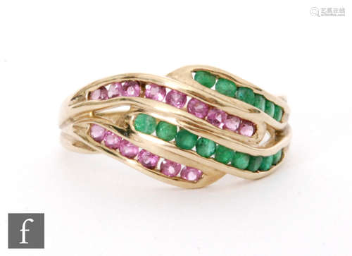 A 9ct hallmarked emerald and pink topaz ring, comprising alternating rows of channel set stones.