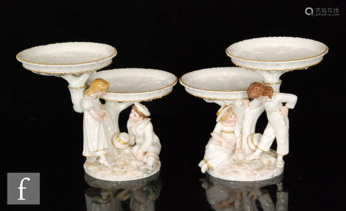 A pair of Royal Worcester figural two tiered comports modelled by James Hadley in the style of