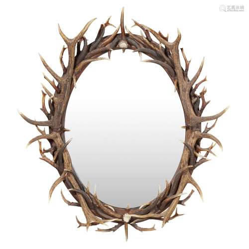 AN ANTLER FRAMED OVAL MIRROR CONTEMPORARY the oval mirrored plate enclosed by entwined antler