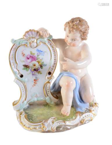 A Meissen menu holder modelled as a kneeling putto with shield