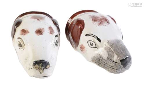Two Staffordshire pottery hounds head stirrup cups painted with brown patches