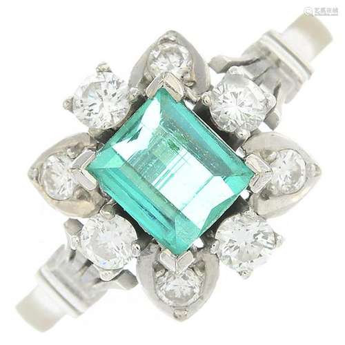 An emerald and diamond cluster ring.Emerald calculated