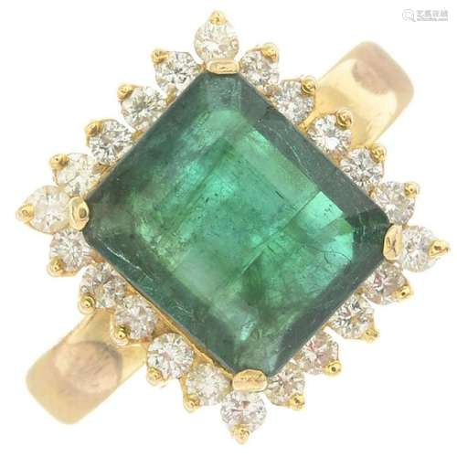An emerald and diamond cluster ring. Emerald calculated