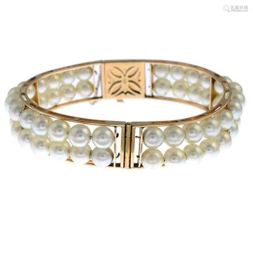 A cultured pearl hinged bangle. Stamped K14. Inner