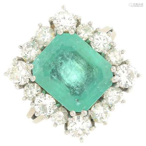 An emerald and diamond cluster ring. Emerald calculated