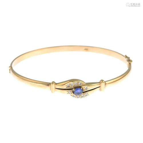 A sapphire and diamond hinged bangle.Stamped 9CT.Inner