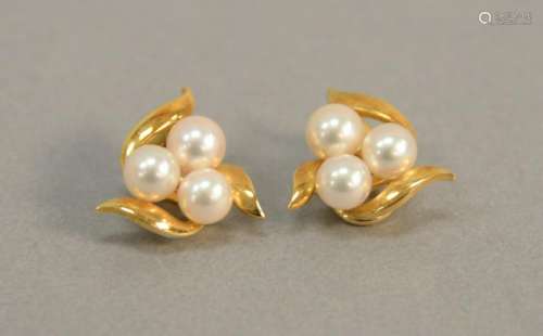 Pair of 18K gold earrings set with three pearls each,
