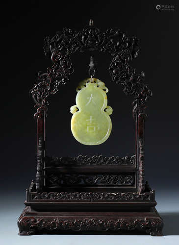 A Chinse Carved Yellow Jade Double Gourd Pendent and Zitan Wood Stand