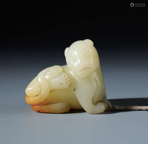 A Finely Carved Chinese White and Russet Jade Recling Beast