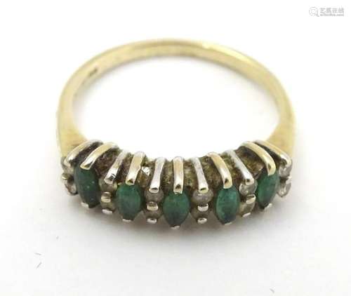 A 9ct gold ring set with emeralds and diamonds.