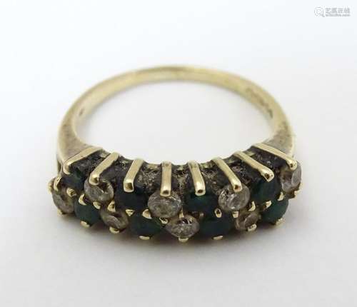 A 9ct gold ring set with white and green stones in a