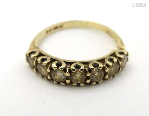 A 9ct gold ring set with 7 white stones in a linear