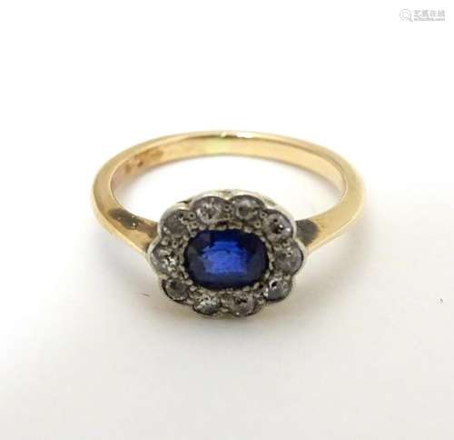 A 9ct gold ring set with central sapphire bordered by