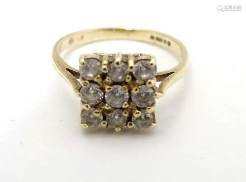 A 9ct gold ring set with 9 white stones in a squared