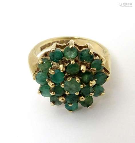 A 9ct gold ring set with a profusion of emeralds