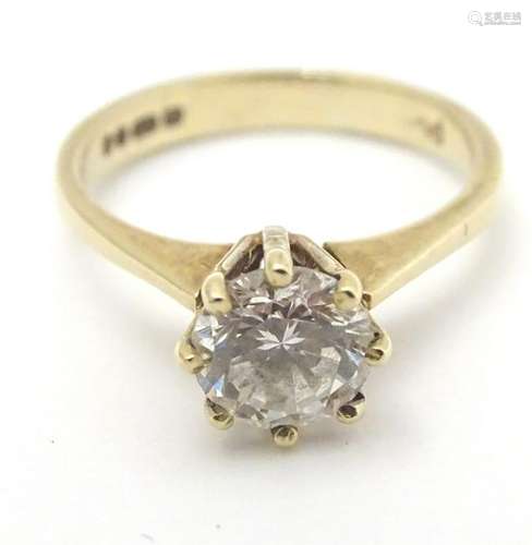 A 9ct gold ring set with central white stone solitaire