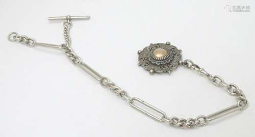 A silver watch chain with ornate Victorian silver fob .