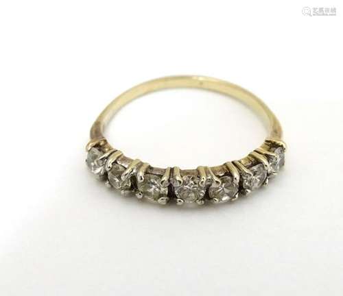 A 9ct gold ring set with 7 white stones in a linear