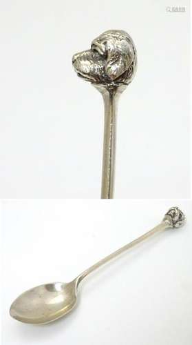 A silver teaspoon the handle surmounted by head of a