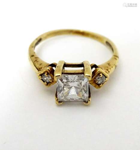 A 9ct gold ring set with square cut white stone flanked