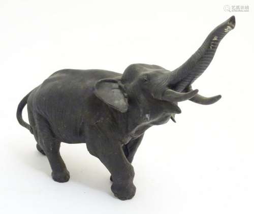 A patinated bronze model of an elephant with its trunk