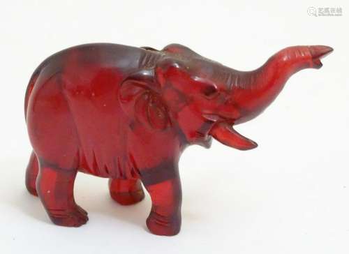 Red Amber: a carved Indian elephant with trunk up, 3''