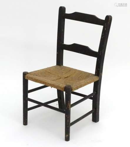 An early 20thC ebonised childs chair with an envelope