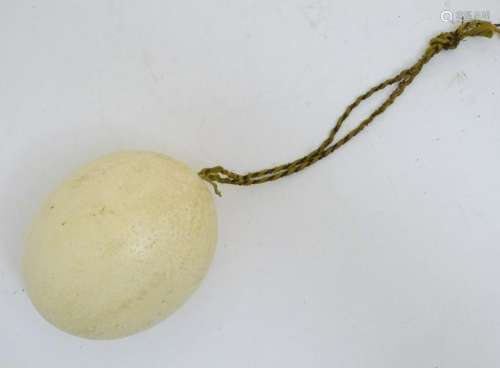 Ostrich Egg: a blown egg with twisted silk rope