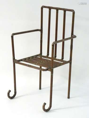 A late 20thC open armchair formed from copper piping.