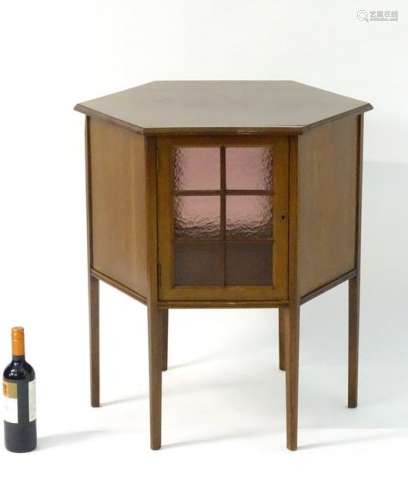 An Edwardian mahogany hexagonal coffee table / cabinet