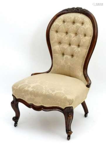 A late 19thC walnut nursing chair with a carved